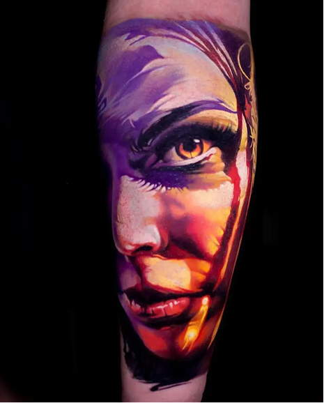Colorful tattoo of a face on a person's arm with a black background